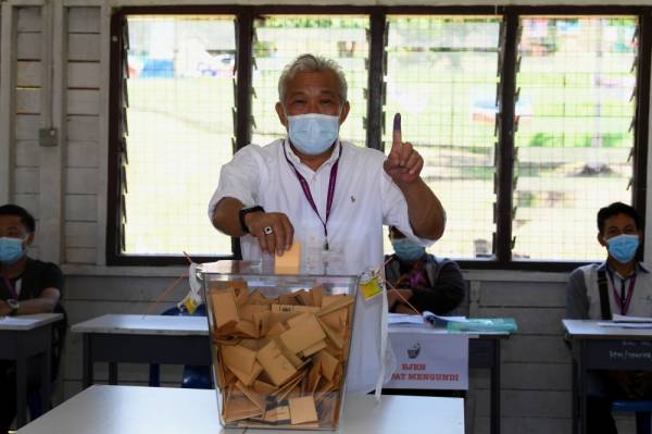 Calon Barisan Nasional (BN) Datuk Seri Bung Moktar Radin mengundi pada Pilihan Raya Negeri Sabah ke-16 di Sekolah Menengah Kebangsaan Bukit Garam hari ini. -Foto Bernama