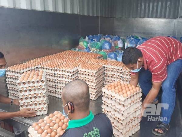 Barangan keperluan makanan diagihkan petugas untuk penduduk Rumah Pangsa Tongkang Yard, Seberang Perak hari ini.