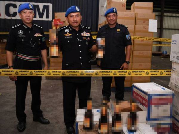 Mohd Yusof (tengah) menunjukkan minuman keras dan pelbagai jenis rokok yang dirampas pada sidang akhbar di Telok Gong, hari ini.