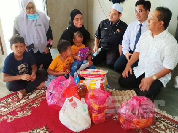 Zulkepli (kanan) bertanyakan khabar Rosida Riza serta anak-anaknya di rumah mereka di Kampung Kusar, Gual Periok, Rantau Panjang hari ini.
