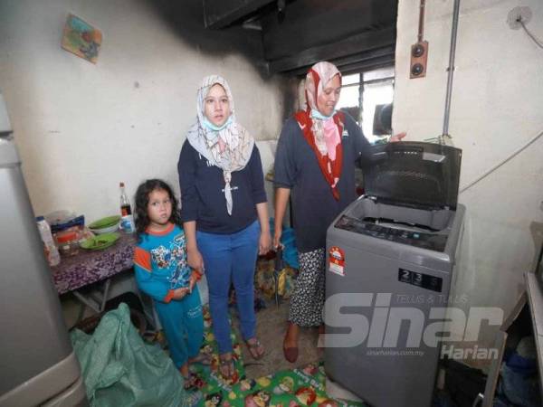 Nuraina Erieka (tengah) bertindak menyelamatkan adiknya bongsunya sewaktu kebakaran berlaku di rumahnya di Flat Taman Anggerik Desa Jalan Beserah pada Rabu lalu.