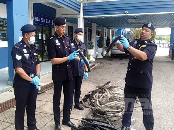 Azhar (kanan) menunjukkan kabel yang dirampas, dipercayai dibakar sebelum dijual.
