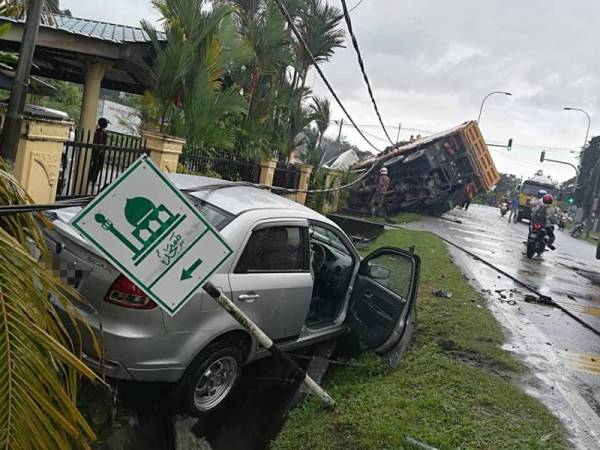 Keadaan kereta Proton Saga dipandu mangsa yang terbabas, manakala lori muatan batu tersebut juga terbabas masuk ke longkang.