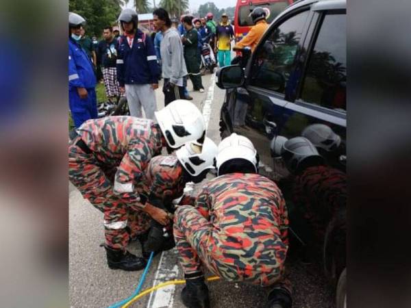 Anggota bomba membantu mengeluarkan mayat mangsa yang terperosok di bawah kereta selepas terbabit kemalangan di Jalan Kuantan-Kemaman di sini, pagi tadi. Foto: Ihsan JBPM Gebeng