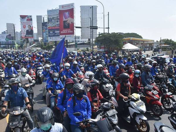 Kumpulan pekerja kilang mengadakan protes membantah undang-undang tersebut yang didakwa mengancam hak pekerja. - Foto: AFP