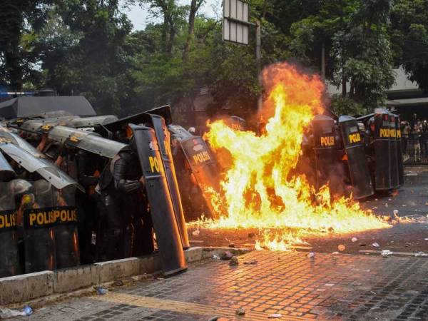 Pasukan polis antirusuhan dibaling bom molotov cocktail ketika tunjuk perasaan ganas di Bandung kelmarin. - Foto AFP