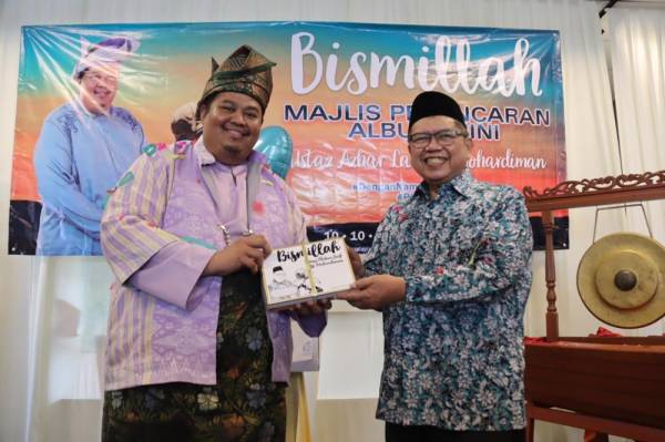 Mohd Azhar bersama Datuk Lat (kanan) menunjukkan album Bismillah yang dilancar di Ipoh kelmarin bagi membantu mengisi dana operasi Pusat Tahfiz Al-Ulya.