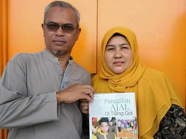 Kamaruddin bersama isterinya menunjukkan salah satu laporan berita berkaitan kematian anaknya yang menjadi kenangan buat mereka berdua.