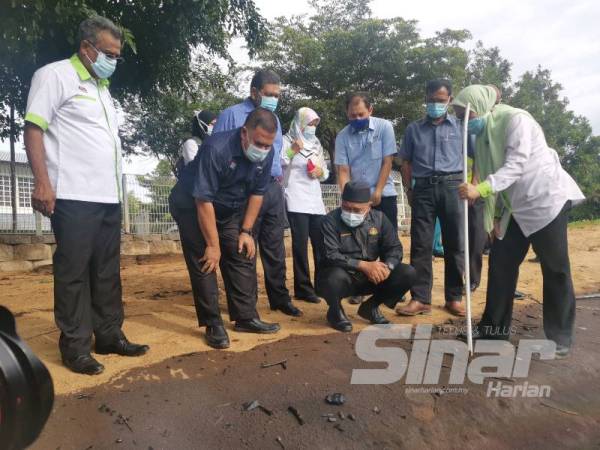 Tuan Ibrahim (duduk) melihat pencemaran di Pantai Cermin hari ini.