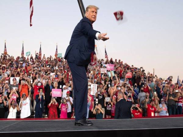 Trump melemparkan pelitup muka ke arah penyokongnya sejurus beliau tiba pada perhimpunan 'Make America Great Again' di Lapangan Terbang Antarabangsa Orlando Sanford di Florida semalam. - Foto AFP