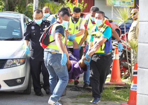 Suspek yang enggan keluar dari kereta diusung oleh enam anggota polis membawanya masuk ke bilik mahkamah bagi prosedur perintah tahanan reman di Mahkamah Majistret Bachok hari ini.