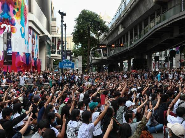 Kumpulan penunjuk perasaan antikerajaan itu menunjukkan isyarat tiga jari ketika berhimpun di Bangkok selepas perintah darurat dikuatkuasakan hari ini. - Foto AFP