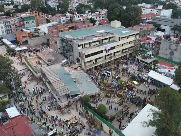 Gambar fail menunjukkan orang ramai menyaksikan kerja-kerja menyelamat sebuah bangunan sekolah yang runtuh di bandar raya Mexico akibat gempa bumi kuat pada tahun 2017. - Foto AFP