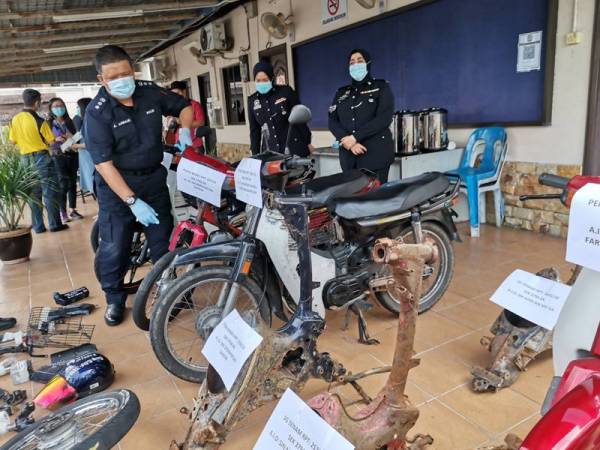 A Asmadi menunjukkan sebahagian komponen dan motosikal curi yang berjaya dirampas dari Geng Farid Temara di Ipoh.