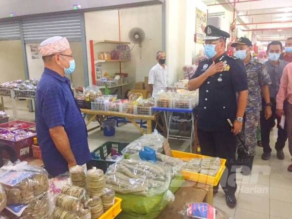 Shafien (kanan) turun padang meninjau pematuhan SOP di Pasar Tasek Raja, Pasir Mas hari ini.