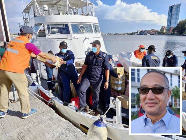 Kakitangan JKM memasukkan barang keperluan ke dalam kapal APMM untuk dihantar ke Pulau Redang hari ini. (Gambar kecil: Zuhami)