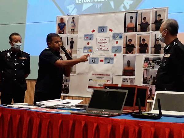 Ayob Khan (tengah) menunjukkan carta aliran pinjaman wang daripada ah long untuk memerangkap mangsanya selepas sidang akhbar di IPK Johor, Johor Bahru hari ini.