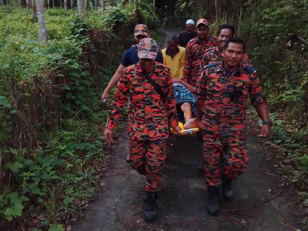 Pasukan penyelamat mengusung Hassan keluar dari lokasi warga emas itu hilang di Kampung Bukit Batu, Kuala Krai hari ini.