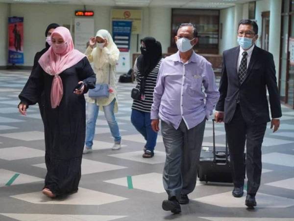 Mokhtar (dua dari kanan) dan isterinya, Noorizan (kiri) hadir di Mahkamah Kuala Lumpur hari ini, atas pertuduhan menggunakan suatu dokumen palsu untuk pembangunan pangsapuri Oktober tahun lalu.