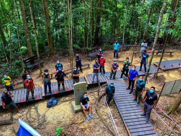 Gotong-royong memasang penanda penjarakan fizikal di Canopy Walkway hari ini.