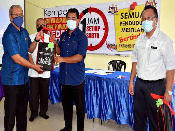 Rahmad (tengah) menyampaikan bahan promosi kepada Setiausaha Majlis Perbandaran Alor Gajah, Datuk Saleh Mohd Dom (kiri) selepas melancarkan Kempen Satu Jam Setiap Sabtu: Cari dan Musnahkan Tempat Pembiakan Nyamuk Aedes di Balai Raya Taman Ayer Molek, Melaka hari ini.- Foto Bernama