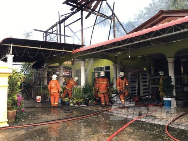 Anggota bomba berusaha memadam kebakaran rumah Hanafiah di Kampung Tanjung Stan, Kubang Kerian petang tadi.