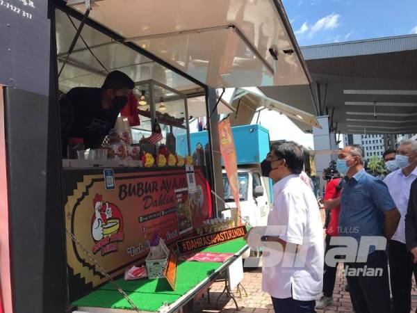 Izhar beramah mesra dengan seorang peniaga selepas merasmikan Majlis Penyerahan Surat Kelulusan Program 3P (Pemulihan, Pemerkasaan dan Peningkatan) Geran Food Truck Johor, Johor Bahru hari ini.