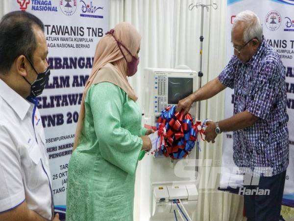 Siti Safinaz (dua dari kiri) melihat Mahdzir menyempurnakan gimik perasmian penyerahan mesin dialisis di Pusat Hemodialisis Syifa Cawangan Pendang hari ini.