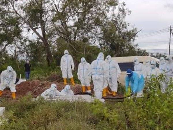 Petugas lengkap PPE menguruskan jenazah Allahyarham Noorzain di Kampung Serusup, Tuaran.