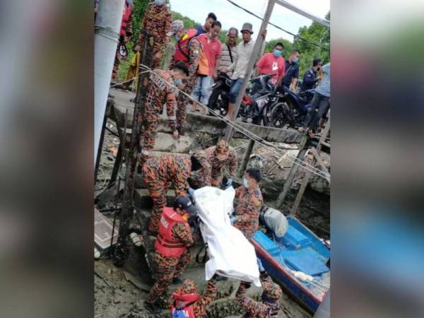 Anggota bomba mengusung jenazah mangsa lemas di Jeti Nelayan Sungai Pulai pagi tadi.