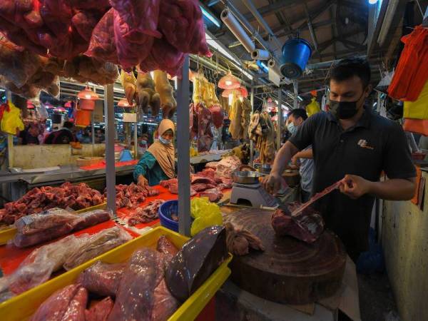 KUALA LUMPUR - Peniaga memotong daging jualan mereka bagi memenuhi permintaan pelanggan sepanjang Perintah Kawalan Pergerakan Bersyarat (PKPB) di deretan gerai bahagian barangan basah di Pasar Chow Kit hari ini. - Foto Bernama