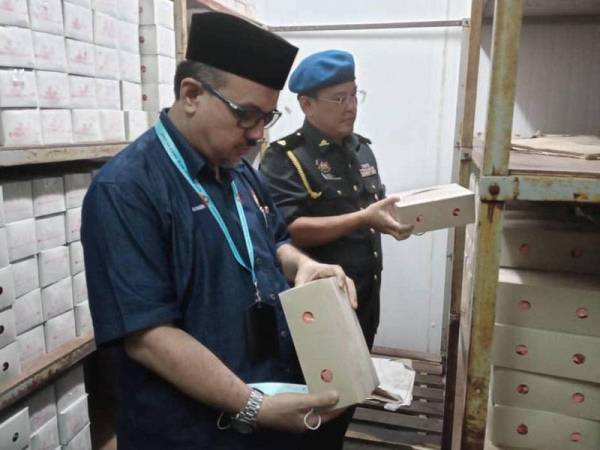 Md Arifin melakukan pemeriksaan terhadap aiskrim dan plastik aiskrim yang mempunyai logo halal di sebuah kilang di Kampung Parit Marjunit, Benut, Pontian semalam.