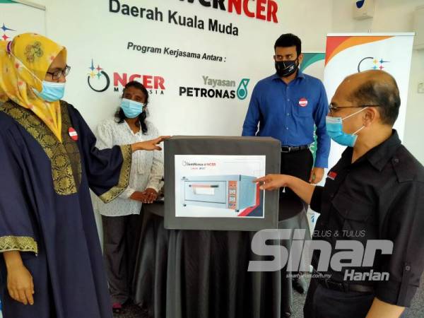 Mashitah (kiri) mengucapkan terima kasih kepada Fauzan (kanan) selepas menerima kit permulaan perniagaan setelah selesai mengikuti program JomNiaga Daerah Kuala Muda semalam.