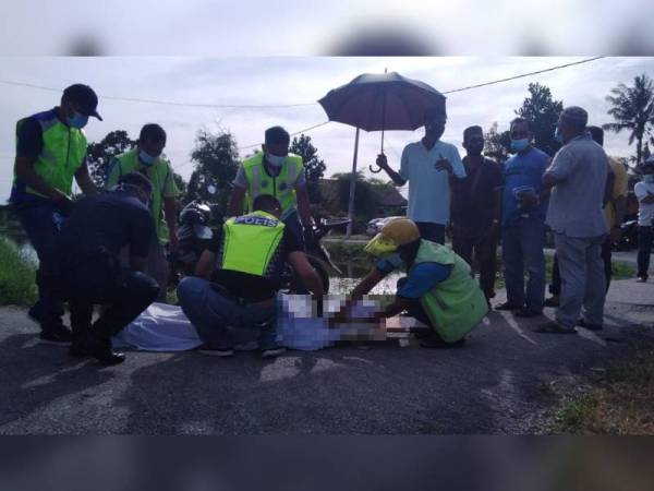 Anggota polis menjalankan pemeriksaan sebelum mayat dibawa ke Hospital Parit Buntar untuk bedah siasat. - Foto Ihsan pembaca