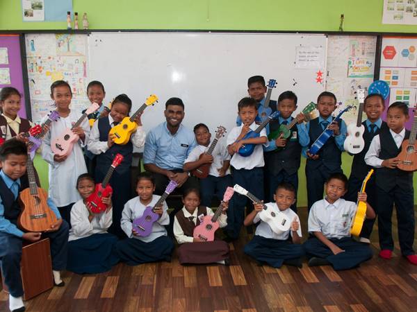 Samuel (tengah) bergambar bersama murid-muridnya yang merupakan anak orang asli di SK Runchang kira-kira 90 kilometer dari Kuantan, Pahang.