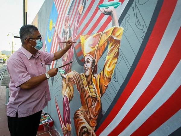 Zazali cuba mewarna lukisan mural di dinding Jalan Yam Tuan di sini.