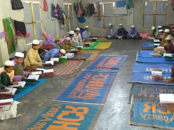 Gambar fail menunjukkan beberapa orang pelajar membaca kitab suci al-Quran di sebuah sekolah agama Islam di Bangladesh. - Foto AFP