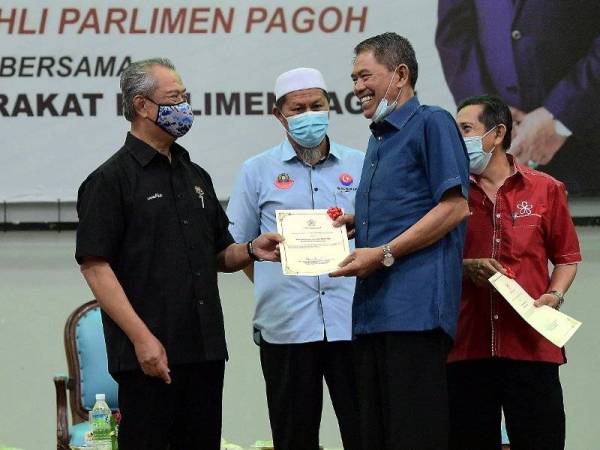 Muhyiddin yang juga Ahli Parlimen Pagoh (dua, kiri) menyampaikan sijil penghargaan kepada Ahli Jawatankuasa Parlimen Pagoh Datuk Tahir Taat pada Majlis Perjumpaan Bersama Pemimpin Masyarakat Parlimen Pagoh di Kompleks Sukan Pagoh hari ini. - Foto Bernama