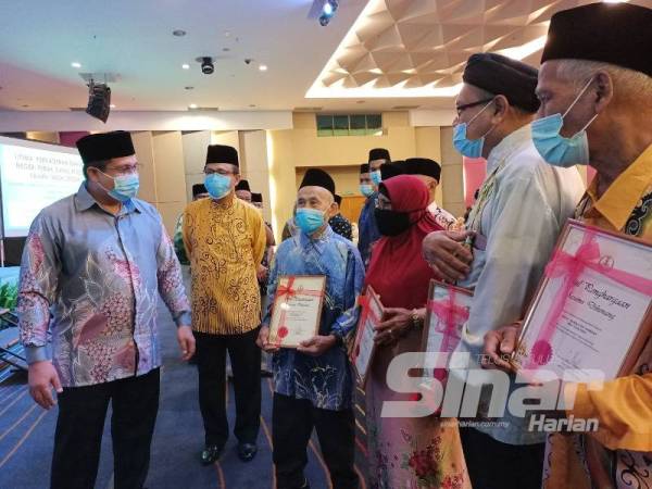 Mohd Akmal (kiri) dan Mohd Yusop (dua dari kiri) bersama barisan penerima sijil penghargaan atas sumbangan mereka sebagai pendakwah lapangan pada program Ijtimak Perkaderan Dakwah Negeri Perak di Pusat Konvensyen Casuarina Meru, Ipoh hari ini.