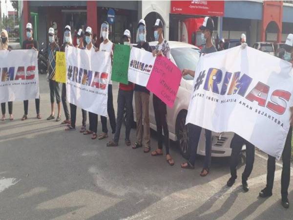 Sekumpulan anak muda memegang poster menggesa ahli politik agar berhenti bermain politik di Jalan Shahab, Alor Setar hari ini.