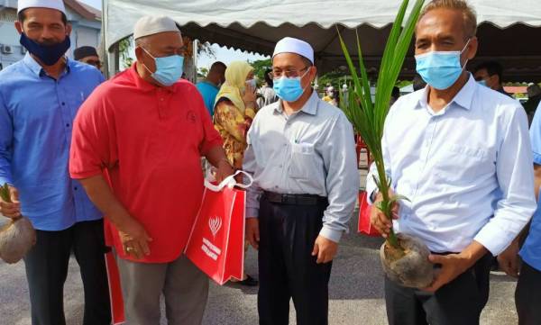 Tuan Mohd Saripudin (dua dari kanan) beramah mesra dengan peserta Program Kelapa Al-Falah ketika hadir di Pejabat Pertanian Pasir Puteh semalam.