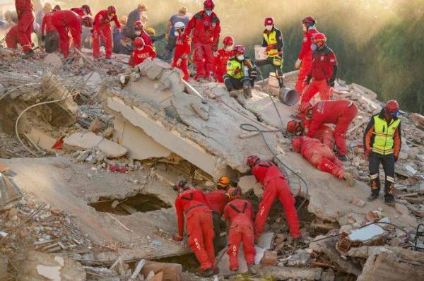 Pasukan penyelamat mencari mangsa di bawah runtuhan bangunan yang roboh akibat gempa di Kota Bayrakli, Turki. - Foto AFP
