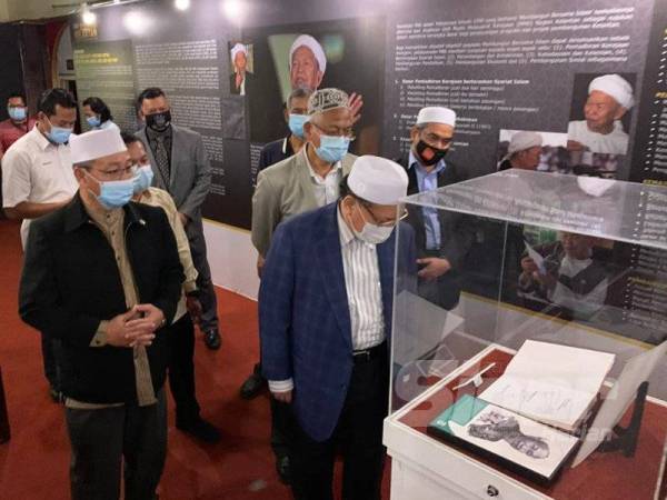 Mohd Amar (tengah) melihat barangan yang dipamerkan di Pameran 3 Dekad Pentadbiran Kelantan Membangun Bersama Islam di Muzium Negeri, Kota Bharu hari ini. 