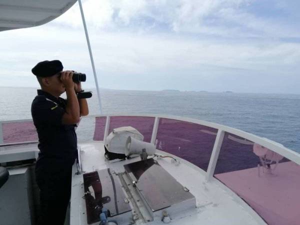 Anggota APMM yang terlibat dalam Operasi Carilamat meninju keadaan di kawasan pencarian bagi mengesan mangsa yang dilaporkan hilang selepas terjatuh daripada bot malam tadi. Foto: Ihsan APMM