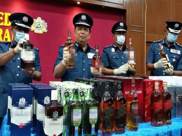 Mohamad (dua dari kiri) menunjukkan minuman keras berkualiti tinggi yang dirampas di sebuah kedai runcit di Ipoh pada sidang media di Wisma Kastam, Ipoh hari ini.