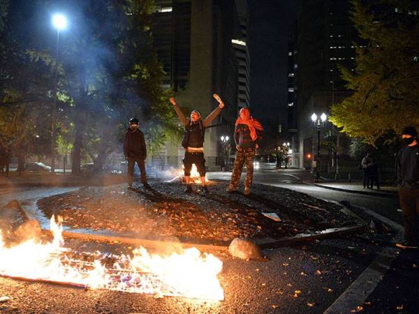 Peserta protes terbabit membakar bendera kebangsaan di luar Mahkamah Persekutuan Portland, Oregon awal pagi tadi. - Foto: AFP