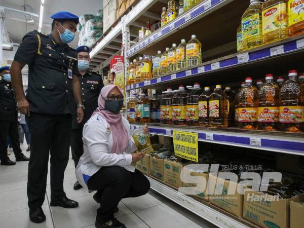 Ain Arjuna menunjukkan bekalan minyak masak peket yang mencukupi dijual di sebuah pasar raya di Seremban hari ini.