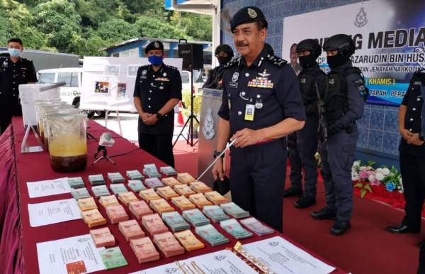 Razarudin menunjukkan wang tunai dan barang kemas yang dirampas.