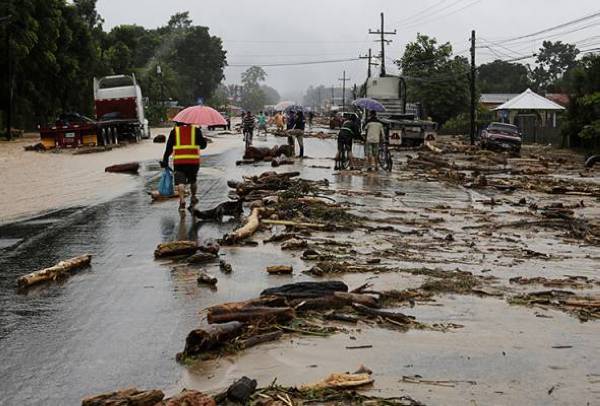 Penduduk melalui sebatang jalan yang terkesan banjir susulan air sungai melimpah akibat hujan lebat ketika Taufan Eta di Toyos, Honduras. Foto Reuters 