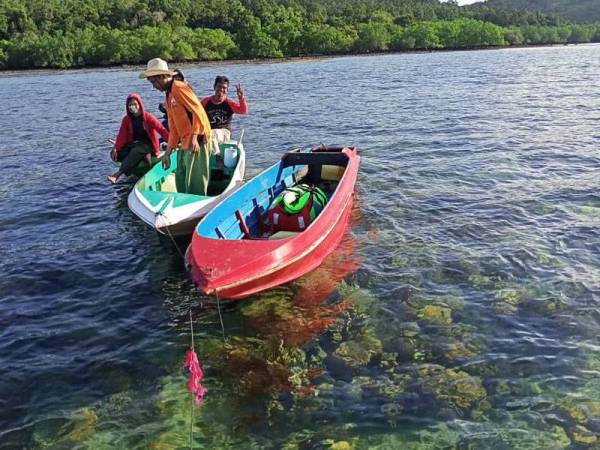 Semua mangsa (belakang) ditemui selamat selepas hanyut kira-kira 15 jam di perairan Kampung Mengkubau, Pitas.